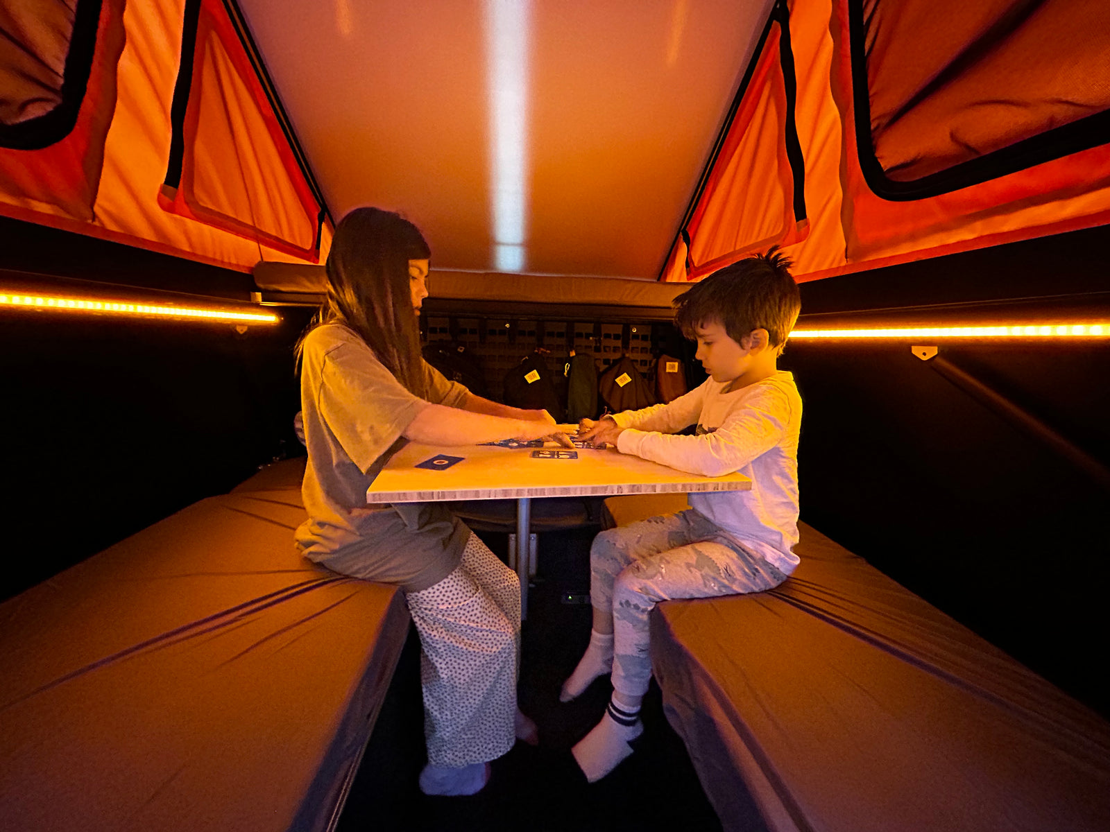 Go Fast Camper (GFC) build - Interior seating playing cards around Lagun table with orange mood lighting